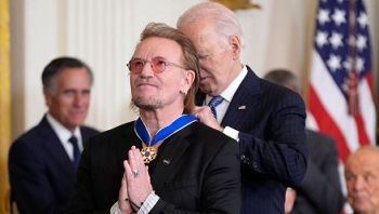 Bono getting medal from Biden