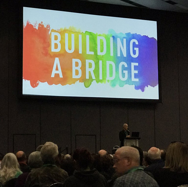 Fr. James Martin at the LA Religious Education Congress in front of a rainbow banner